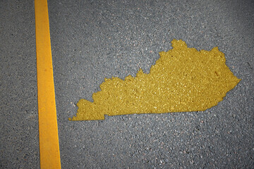yellow map of kentucky state on asphalt road near yellow line.