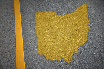 yellow map of ohio state on asphalt road near yellow line. - obrazy, fototapety, plakaty