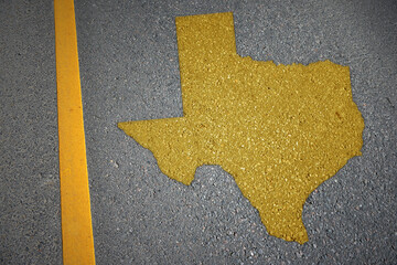 yellow map of texas state on asphalt road near yellow line. - obrazy, fototapety, plakaty