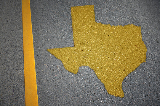 yellow map of texas state on asphalt road near yellow line.