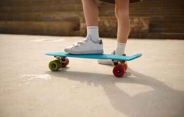 Skateboarding legs. Close-up child legs on a skateboard.