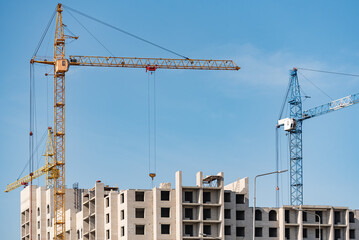 Fototapeta premium A construction site with a tower crane erecting a new house.