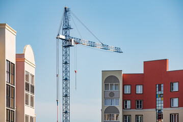 A construction site with a tower crane erecting a new house.