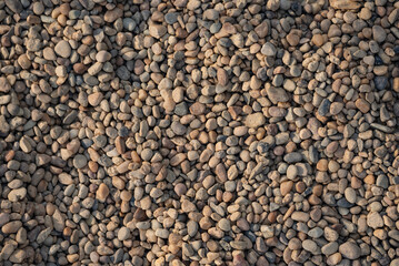Texture of river gray-ochre pebbles, gravel, top view.