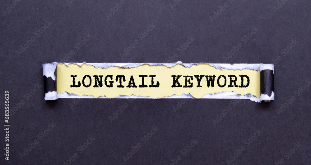 Poster woman s hand holds a piece of paper with text longtail keyword on the background of graphs and notep
