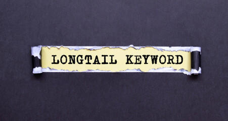 woman s hand holds a piece of paper with text Longtail Keyword on the background of graphs and...