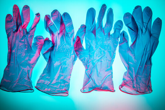Blue plastic disposable gloves backlit with pink highlights