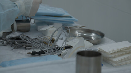A table of medical tools are placed upon a table in preparation for surgery. Stock footage. Nurse...