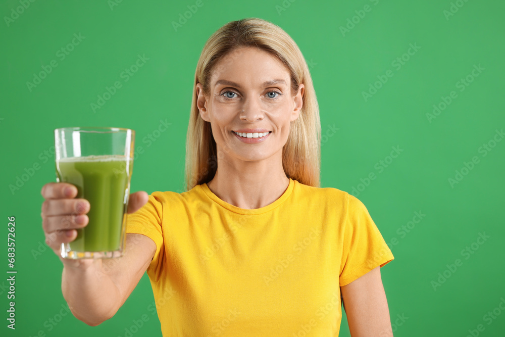 Wall mural Woman with glass of tasty celery juice on green background