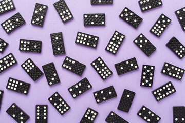 Black domino tiles on color background, top view