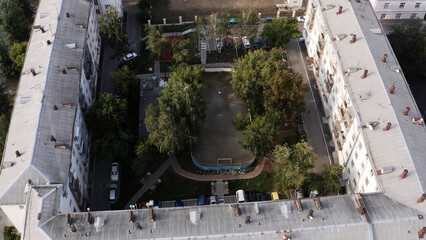 Small green summer courtyard surrounded by square shaped residential houses. Stock footage. Top...