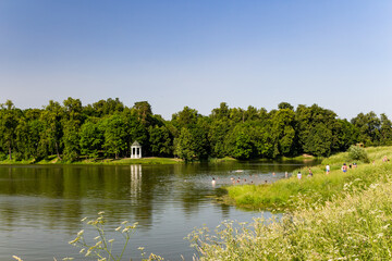 Summer landscape with a pond where people relax and swim