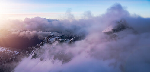 Mountain Peak Covered in Snow. Winter Season. Cloudy Sunset. Aerial View.