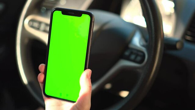 person using a key, female hand holding mobile phone in car, phone green screen in car 