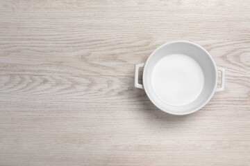 One empty pot on white wooden table, top view. Space for text