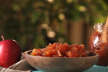 Delicious apple jam and fresh fruit on light blue wooden table against blurred background, closeup. Space for text