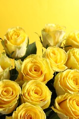 Beautiful bouquet of roses on yellow background, closeup