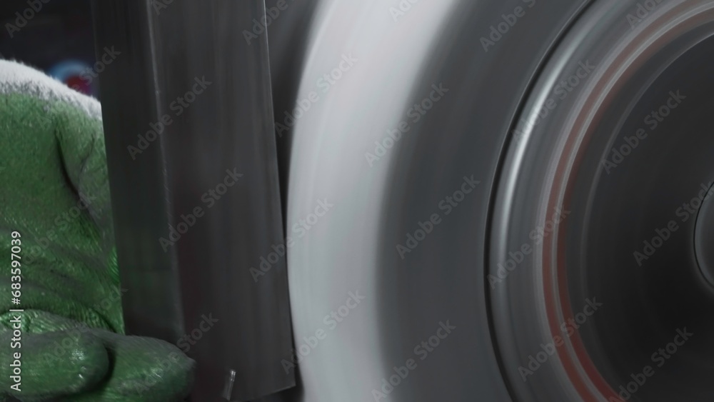 Poster close-up polishing of steel part on rotating machine. creative. rectangular steel part is polished o