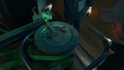 Sheet bending press at factory. Creative. Workers bend metal pipe on old production machine. Steel...