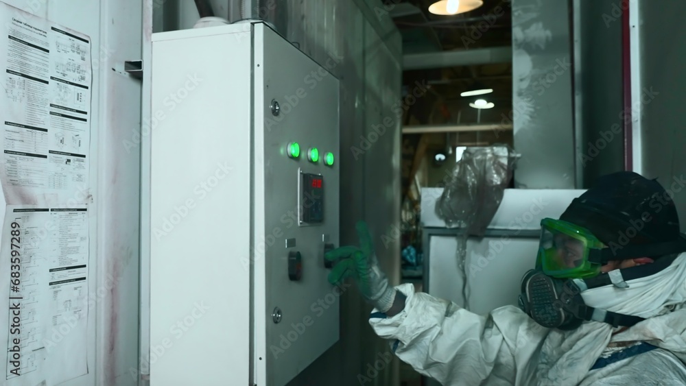 Poster worker in work uniform presses control panel of factory machines. creative. worker in mask and unifo