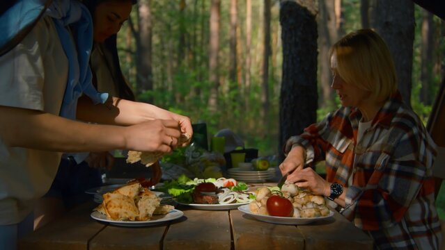 People Prepare Table In Gazebo In Nature. Stock Footage. Family Cooks Food Outdoors On Sunny Summer Day. Outdoor Recreation With Family And Friends In Gazebo With Barbecue