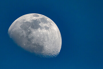 3/4 moon against a cloudless blue sky