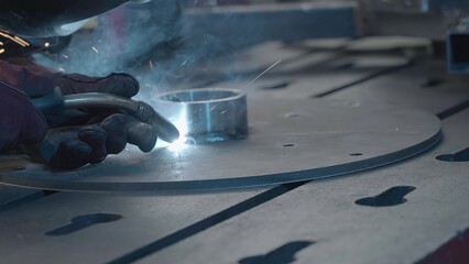 Welder in gloves holds welding with flying sparks. Creative. Sparks while working with welding and...