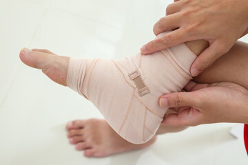 Man with ankle sprain elastic bandage for ankle injury and feeling pain - obrazy, fototapety, plakaty