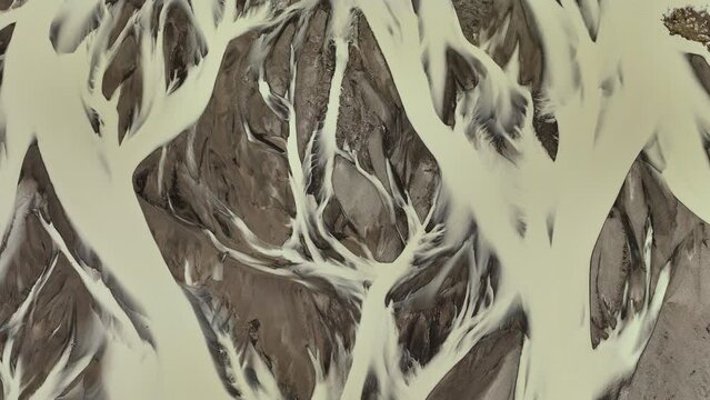 Aerial view of braided river patterns on the South Coast of Iceland looking down at the water.