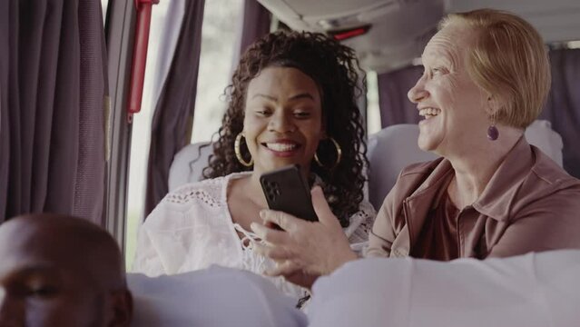 Senior woman taking a picture of something through the bus window using her smartphone. Cinematic 4k.