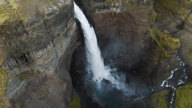 Aerial view of Háifoss waterfall in southern Iceland slowing flying towards it from above.