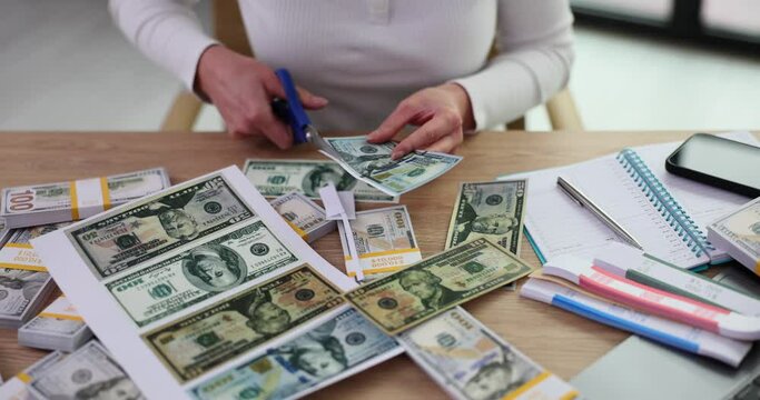 Closeup of woman cutting out printed American dollar