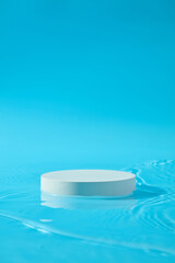 Front view of an empty podium in white color decorated over blue background. Studio podium or platform product template mockup