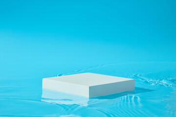 Blue background featured a white podium in square shaped. Pastel minimal wall scene collection. Modern platform for product display presentation