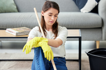 Cleaning, burnout and an unhappy woman in the living room of her home for housework chores. Sad,...