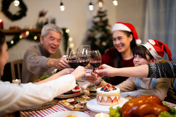 Cheers wineglass celebrate in Xmas greeting invitation while Asian family gathering dinner party...