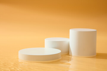 A set of three white podium in geometric shapes arranged. Platforms cosmetic product presentation. Orange background for beauty products