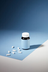 The white tablets are displayed with an unlabeled medicine bottle against a blue-white background....