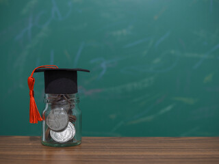 Close up money in the glass bottle with graduation hat. The concept of saving money for education,...