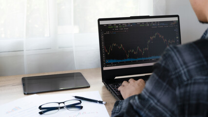 Analyst, investor, businessman using laptop for crypto financial market analysis Index chart,...