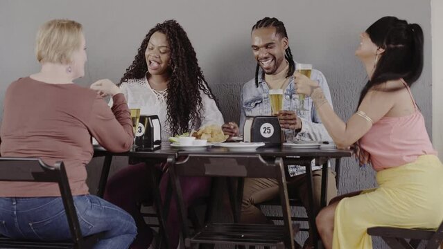 Pessoas felizes de diferentes idades desfrutando de uma bebida em bar ao ar livre. Cinemtico 4k.