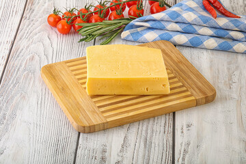 Piece of natural organic cheese over board