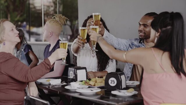 Alegre mulher senior, se divertindo durante happy hour com amigos mais jovens. Cinematico 4k.
