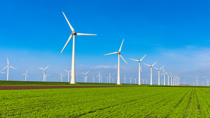 Windmill turbines with blue sky, windmill turbines on land and in the ocean Netherlands Europe  © Chirapriya