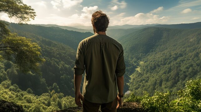 Young man from behind looking at the horizon from the top of a mountain in the jungle, on a sunny summer day. Health. Nature. Lifestyle. Image generated with AI