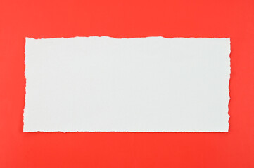 White torn paper on a red background.