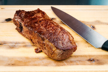 Rumpsteak wird auf Holzbrett geschnitten
