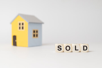 Close-up of House model with sold sign, isolated on white background