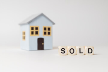 Fototapeta na wymiar Close-up of House model with sold sign, isolated on white background