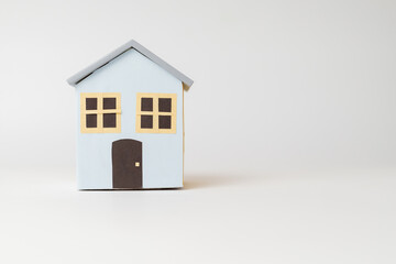 Obraz na płótnie Canvas Miniature sky blue model house with windows and doors, on white background